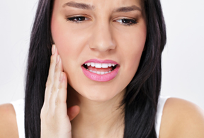 woman who needs to see an emergency dentist due to toothache